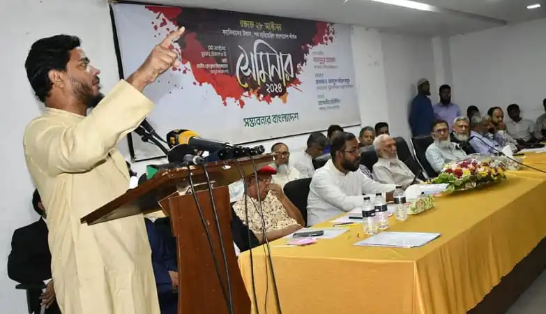 শফিকুল ইসলাম মাসুদ বক্তৃতা দিচ্ছেন, বিশিষ্ট ব্যক্তিরা উপস্থিত. Channel i News - চ্যানেল আই নিউজ