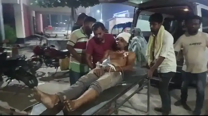 আহত ব্যক্তি হাসপাতালে নেওয়া হচ্ছে, বেশ কয়েকজন মানুষ তাকে সাহায্য করছে. Channel i News - চ্যানেল আই নিউজ