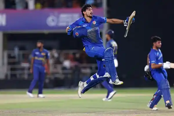 আফগানিস্তানের ক্রিকেটার জয় উদযাপন করছে, অন্য খেলোয়াড়রা পেছনে দেখা যাচ্ছে. Channel i News - চ্যানেল আই নিউজ