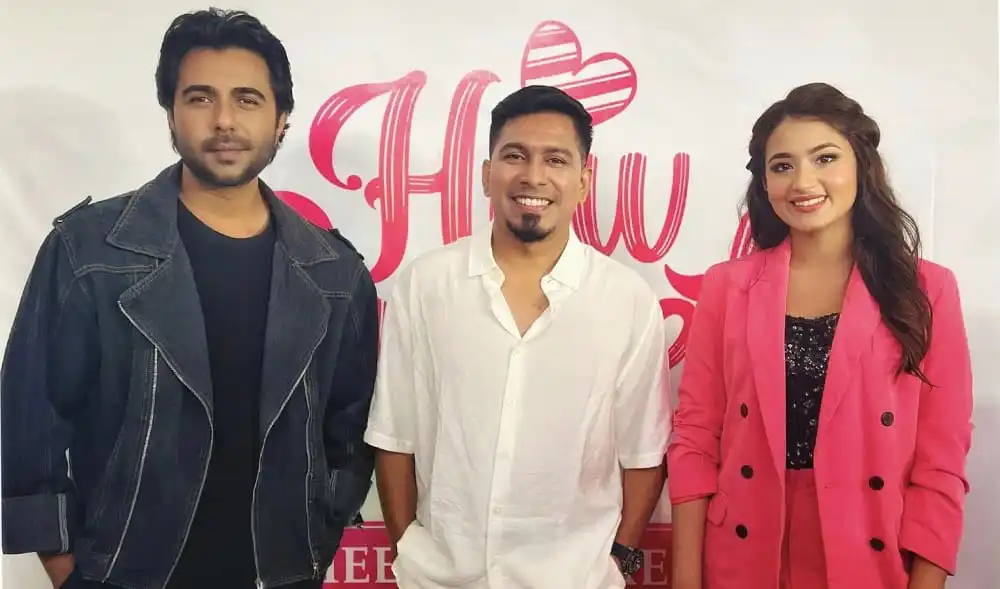 তিনজন মানুষ হাসিমুখে ছবি তুলেছেন, পেছনে হাউ সুইট লেখা ব্যানার. Channel i News - চ্যানেল আই নিউজ