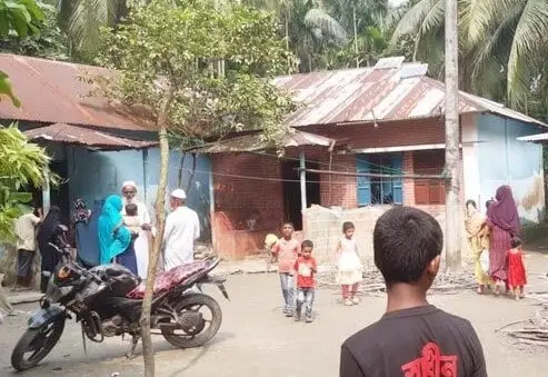 বস্তি এলাকার শিশু ও নারীসহ মানুষজনের ভিড়, একটি মোটরসাইকেল পাশে দাঁড়িয়ে. Channel i News - চ্যানেল আই নিউজ