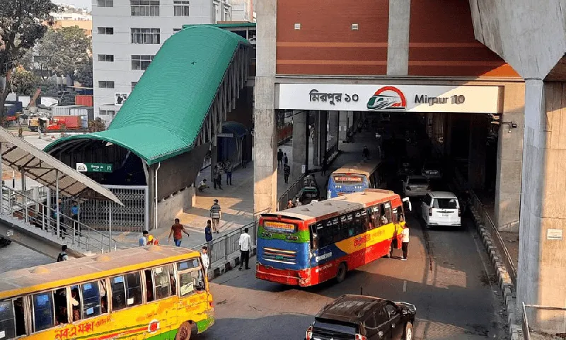 Mirpur 10 metro station entrance with buses and pedestrians in Dhaka, Bangladesh. Channel i News - চ্যানেল আই নিউজ