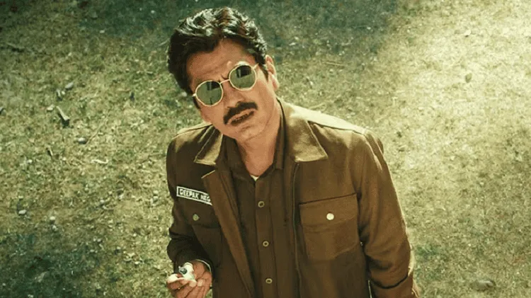 নওয়াজউদ্দিনের আইনি বিপাকের ছবি, সেলফি হাতে, গাঢ় সবুজ পটভূমিতে. Channel i News - চ্যানেল আই নিউজ