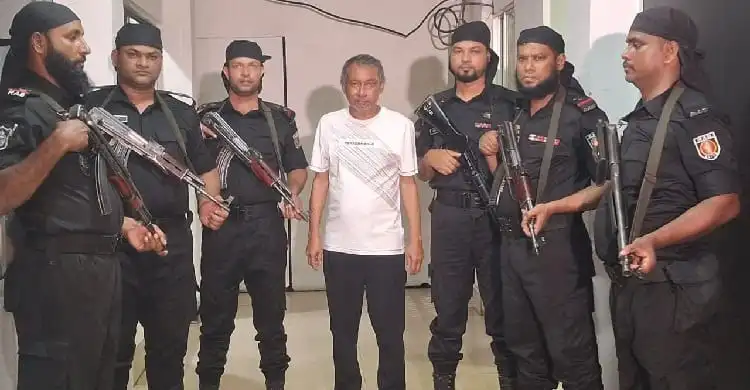 চট্টগ্রামে গ্রেপ্তার একরামুল করিমের ছবি, পুলিশ সদস্যরা তার চারপাশে অবস্থান করছেন. Channel i News - চ্যানেল আই নিউজ