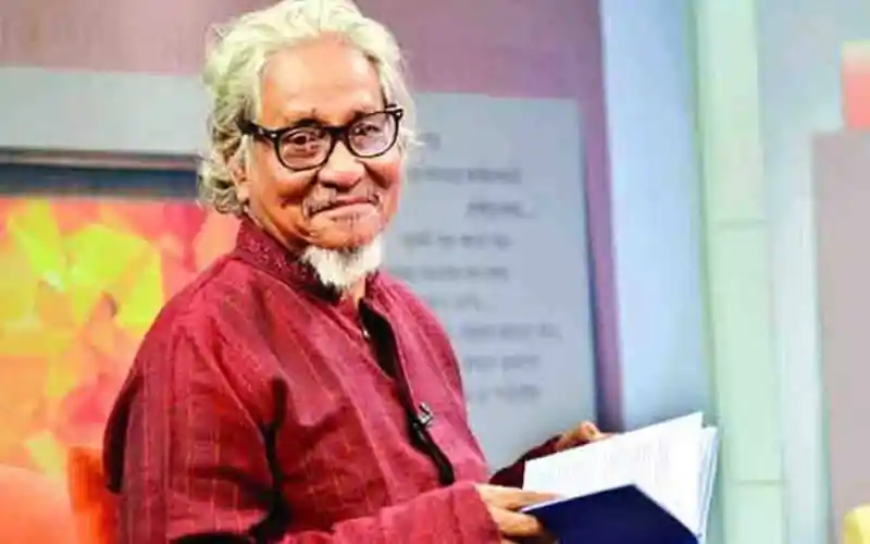 কবি আসাদ চৌধুরীর স্মরণসভায় উপস্থিত একজন ব্যক্তি, হাসিমুখে বই হাতে. Channel i News - চ্যানেল আই নিউজ