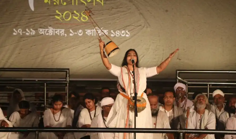 একজন নারী গায়ক সঙ্গীত পরিবেশন করছেন, ব্যাকগ্রাউন্ডে অন্যান্য শিল্পীরা উপস্থিত. Channel i News - চ্যানেল আই নিউজ