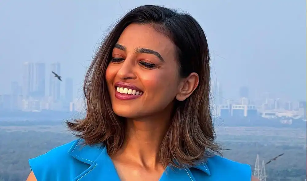 অভিনেত্রী রাধিকা আপ্তে হাসিমুখে, আকাশ ও শহর পটভূমিতে. Channel i News - চ্যানেল আই নিউজ