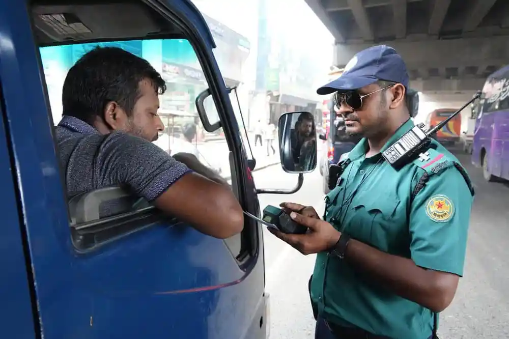 ট্রাফিক পুলিশ ড্রাইভারের ড্রাইভিং লাইসেন্স পরীক্ষা করছে. Channel i News - চ্যানেল আই নিউজ