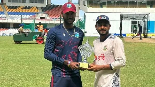 Cricket players holding a trophy on the field at a stadium. Channel i News - চ্যানেল আই নিউজ
