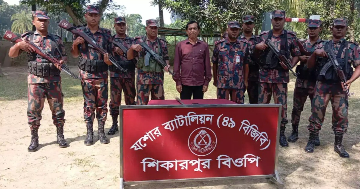 শিক্ষানবিশ ব্যাটালিয়ন শিবিরের সদস্যরা অস্ত্র হাতে দাঁড়িয়ে. Channel i News - চ্যানেল আই নিউজ