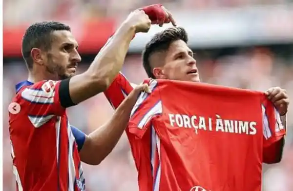 Two football players celebrating with a red jersey in a stadium. Channel i News - চ্যানেল আই নিউজ