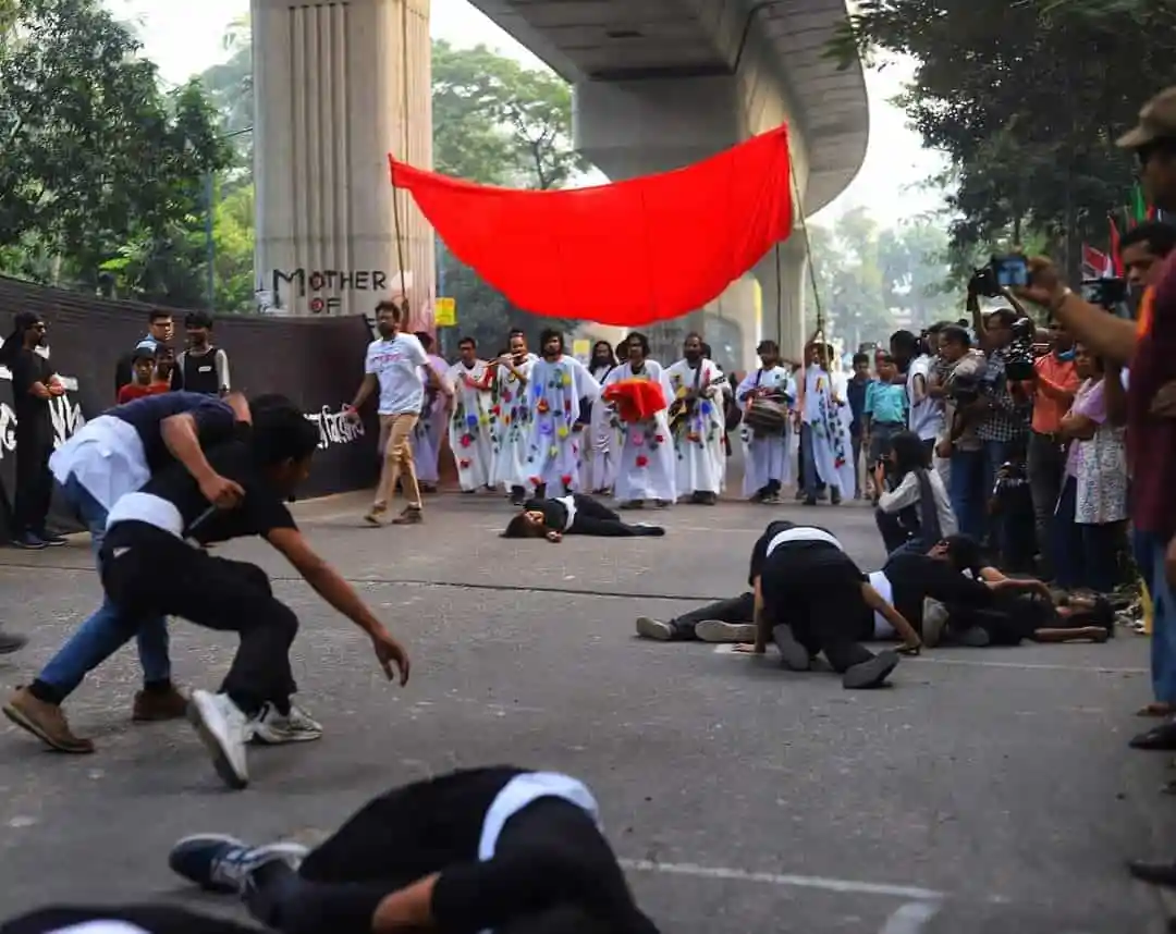 প্রতিবাদে অংশ নেওয়া মানুষজনের ছবি, লাল পতাকা ও নাচের দৃশ্য. Channel i News - চ্যানেল আই নিউজ