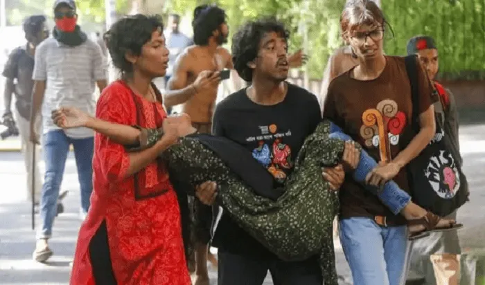 আহত ব্যক্তিকে হাসপাতালে নিয়ে যাওয়ার জন্য সহায়তা করছে মানুষ. Channel i News - চ্যানেল আই নিউজ