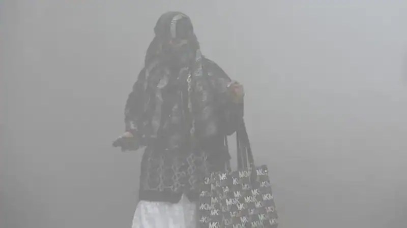 ধূসর বায়ু দূষণের মধ্যে নারী মুখোশ পরে চলাফেরা করছে. Channel i News - চ্যানেল আই নিউজ