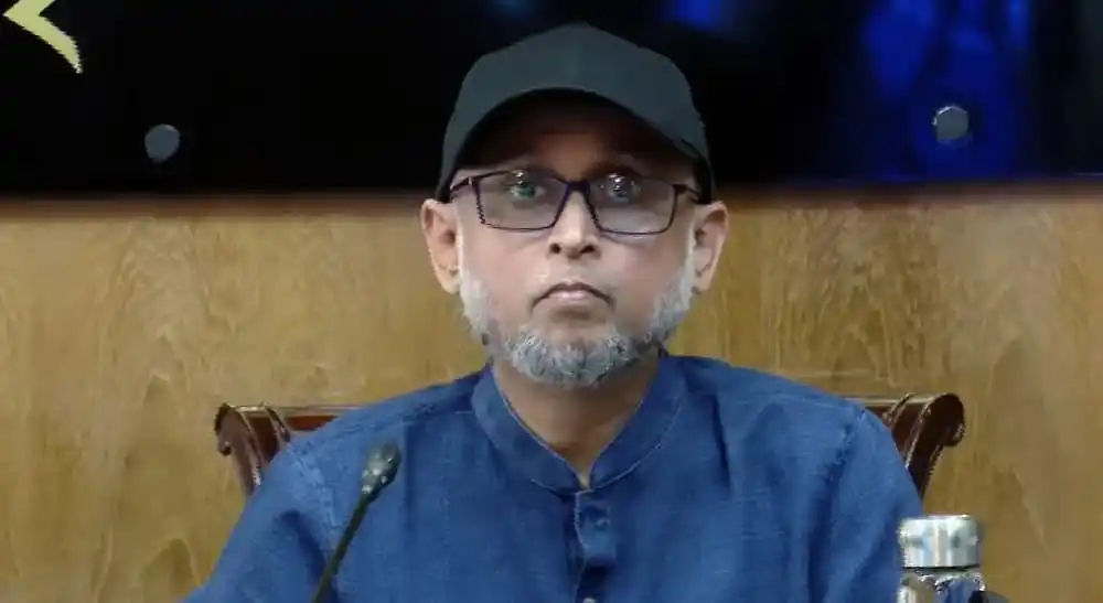 বাংলাদেশের একজন নেতা বা বক্তা, গম্ভীর মুখে বসে আছেন. Channel i News - চ্যানেল আই নিউজ