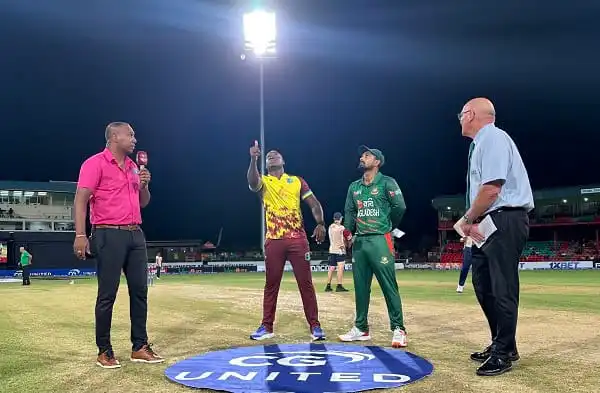 Cricket players and officials on the field during a night match at a stadium. Channel i News - চ্যানেল আই নিউজ
