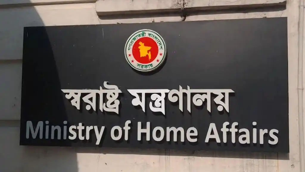 স্বরাষ্ট্রমন্ত্রালয় ভবনের সামনে বোর্ডের ছবি, বাংলায় লেখা. Channel i News - চ্যানেল আই নিউজ