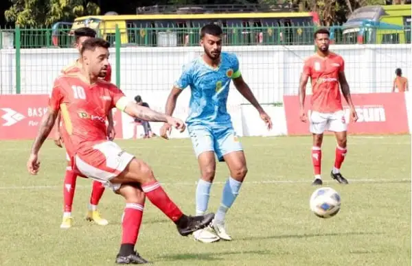 বাংলাদেশি ফুটবল খেলোয়াড়রা মাঠে খেলছে, একদল আক্রমণে রয়েছে।. Channel i News - চ্যানেল আই নিউজ