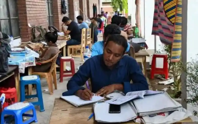 পরীক্ষার্থীরা পরীক্ষার জন্য প্রস্তুতি নিচ্ছেন, বই ও নোটের পাশে বসে. Channel i News - চ্যানেল আই নিউজ