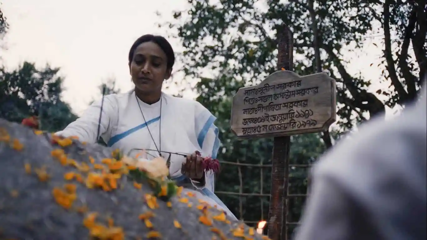 একজন নারী ফুল দিয়ে স্মৃতিসৌধে শ্রদ্ধা জানাচ্ছেন।. Channel i News - চ্যানেল আই নিউজ