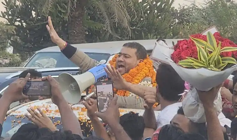 Bangladeshi politician addressing supporters with a megaphone at a rally. Channel i News - চ্যানেল আই নিউজ
