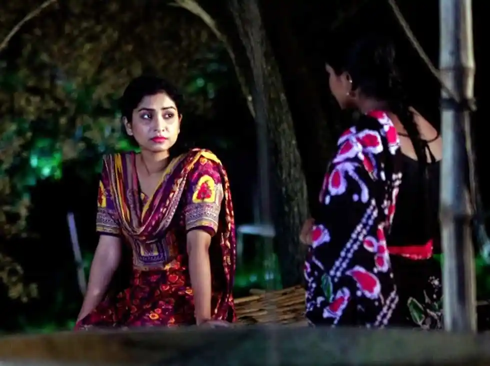 দুই নারী একে অপরের সাথে কথা বলছেন, একটি গাছের নিচে বসে।. Channel i News - চ্যানেল আই নিউজ