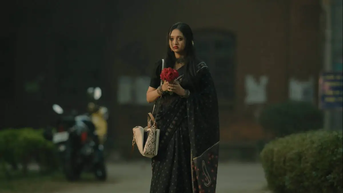 একজন নারী রাস্তার পাশে দাঁড়িয়ে ফুল হাতে ধরেছেন।. Channel i News - চ্যানেল আই নিউজ