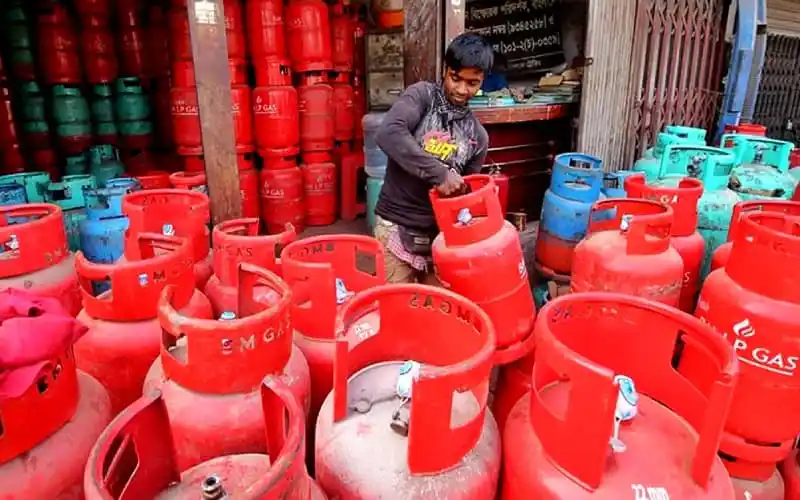 বাজারে বিভিন্ন রঙের গ্যাস সিলিন্ডার দেখাচ্ছে একজন ব্যক্তি. Channel i News - চ্যানেল আই নিউজ