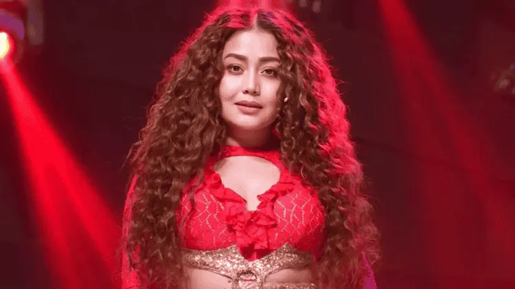নেহা কক্কর পারফর্মিং করছেন, লাল পোশাক পরা, স্টেজে আলোতে আলোচিত।. Channel i News - চ্যানেল আই নিউজ