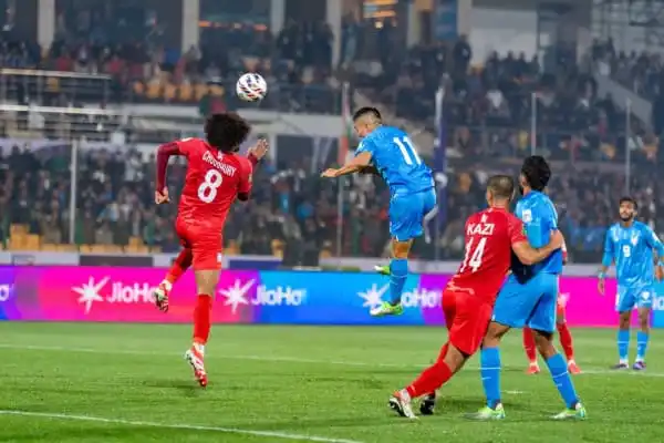 বাংলাদেশ ও ভারতের ফুটবল ম্যাচের দৃশ্য, খেলোয়াড়রা লড়াই করছে. Channel i News - চ্যানেল আই নিউজ