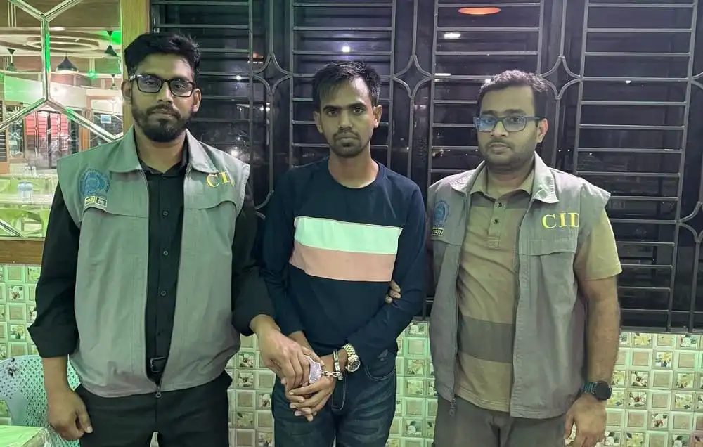 তিনজন ব্যক্তি, একজনের হাতে হাতকড়া, বাংলাদেশি পুলিশ সদস্যরা।. Channel i News - চ্যানেল আই নিউজ