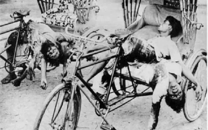Black and white photo showing injured people on a tricycle after an incident. Channel i News - চ্যানেল আই নিউজ