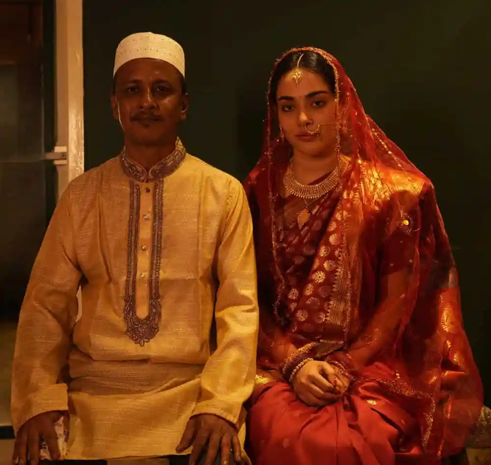 একজন পুরুষ ও একজন নারী ঐতিহ্যবাহী পোশাকে বসে থাকছেন. Channel i News - চ্যানেল আই নিউজ