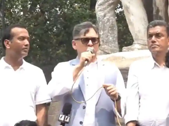 বাংলাদেশের রাজনৈতিক নেতা বক্তৃতা দিচ্ছেন, পাশে দুই সহকর্মী।. Channel i News - চ্যানেল আই নিউজ