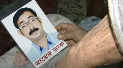 নিখোঁজ সুমনের ছবি হাতে ধরে দুঃখপ্রকাশ করছেন একজন ব্যক্তি. Channel i News - চ্যানেল আই নিউজ