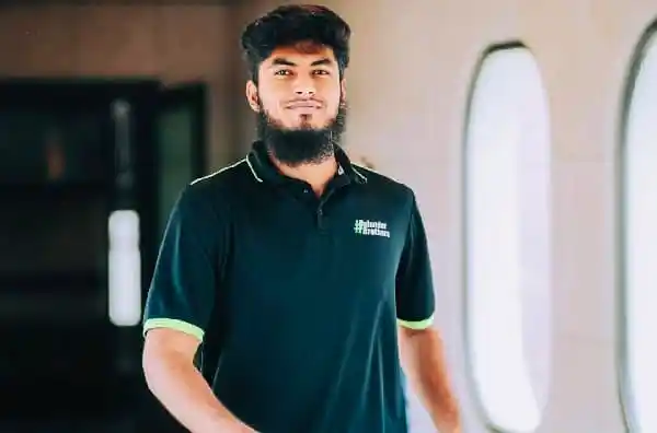 বাংলাদেশি যুবক পেশাদার পোশাক পরিহিত, হাসিমুখে দাঁড়িয়ে. Channel i News - চ্যানেল আই নিউজ