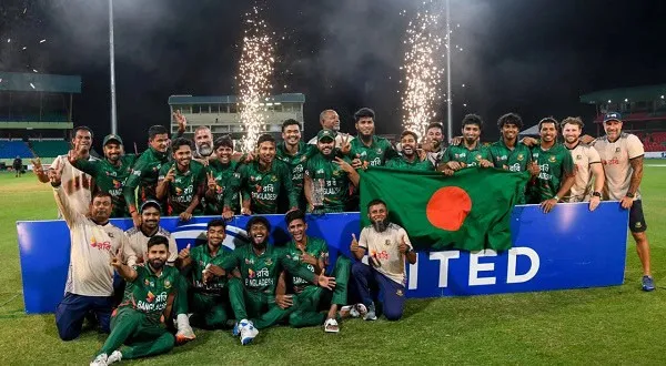 বাংলাদেশ ক্রিকেট দল উদযাপন করছে মাঠে, পতাকা হাতে।. Channel i News - চ্যানেল আই নিউজ