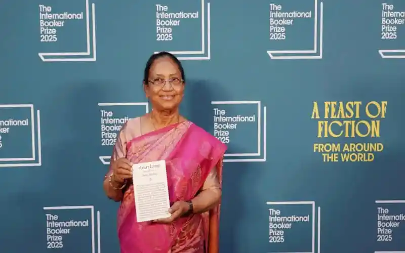 বানু মুশতাক বুকার পুরস্কার গ্রহণ করছেন, পটভূমিতে আন্তর্জাতিক বুকার পুরস্কার ব্যানার. Channel i News - চ্যানেল আই নিউজ