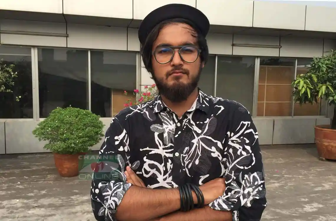 নোবেল গ্রেপ্তার সংক্রান্ত যুবকের ছবি, তিনি কালো হ্যাট ও চেক শার্ট পরেছেন. Channel i News - চ্যানেল আই নিউজ