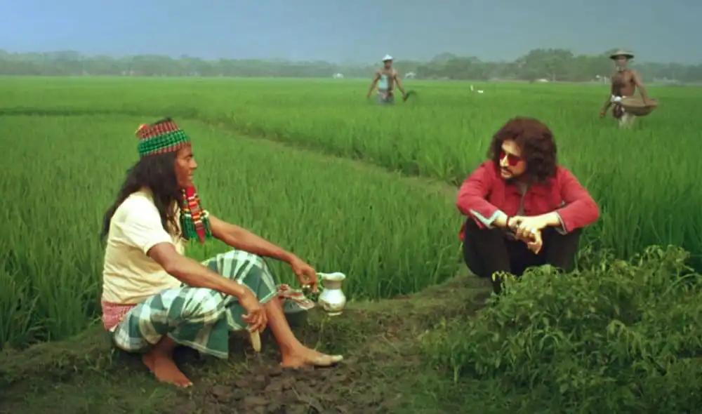 কৃষকদের কাজের দৃশ্য, ধানক্ষেতের পাশে বসে আলোচনা করছে দুই ব্যক্তি. Channel i News - চ্যানেল আই নিউজ