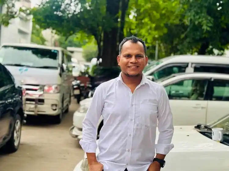 স্মার্ট ব্যক্তির হাসিমুখে ছবি, বাইরের পরিবেশে. Channel i News - চ্যানেল আই নিউজ