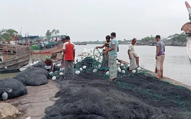 জেলেরা সমুদ্রে ফেরার জন্য প্রস্তুতি নিচ্ছেন, মাছ ধরার জাল ও নৌকা পাশে. Channel i News - চ্যানেল আই নিউজ