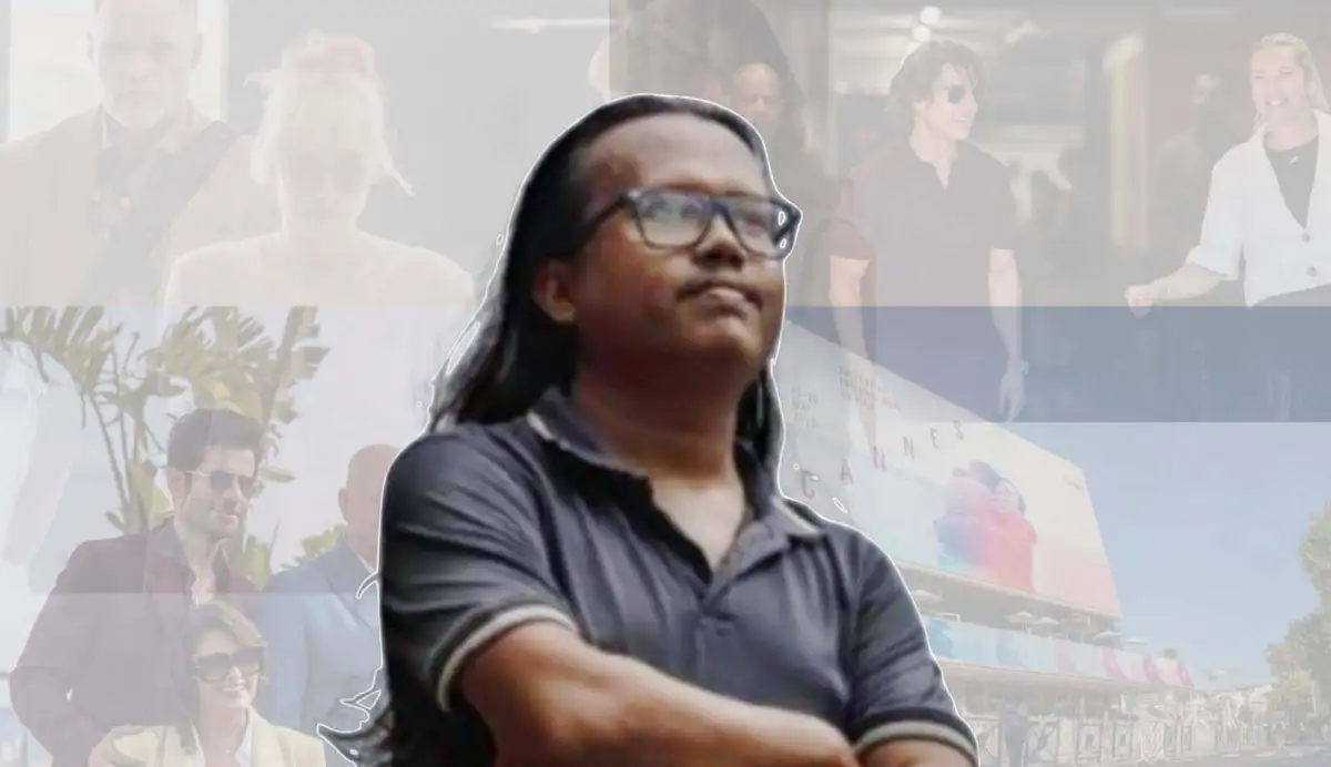 একজন ব্যক্তি চোখ বন্ধ করে দাঁড়িয়ে আছেন, পেছনে বিভিন্ন মানুষ ও স্থান দেখা যাচ্ছে. Channel i News - চ্যানেল আই নিউজ
