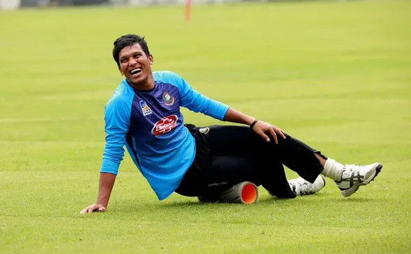 ক্রিকেটার সাইফউদ্দিন হাস্যোজ্জ্বলভাবে মাঠে বসে আছেন. Channel i News - চ্যানেল আই নিউজ