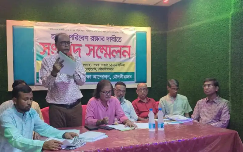 সংবাদ সম্মেলনে বক্তা বক্তব্য দিচ্ছেন, প্যানেল সদস্যরা উপস্থিত. Channel i News - চ্যানেল আই নিউজ
