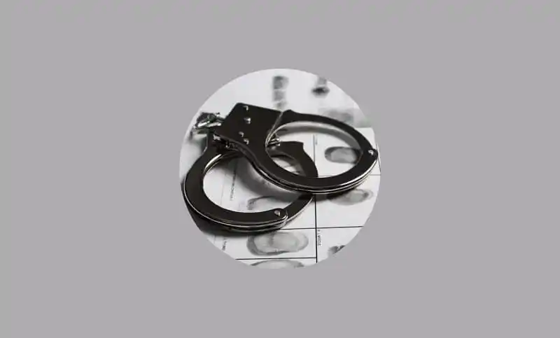 Police handcuffs on a reflective surface, symbolizing law enforcement. Channel i News - চ্যানেল আই নিউজ