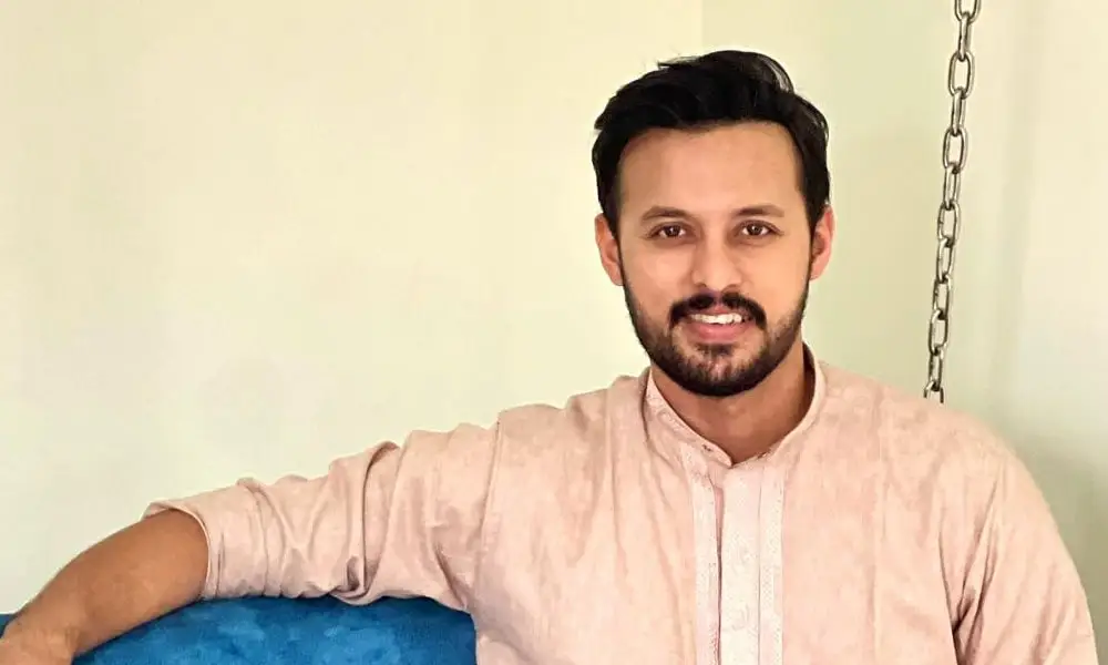 আনন্দিত যুবক হাসিমুখে বসে, শান্তিপূর্ণ পরিবেশে. Channel i News - চ্যানেল আই নিউজ