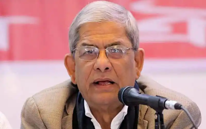 Senior man speaking at a press conference with microphone in front. Channel i News - চ্যানেল আই নিউজ