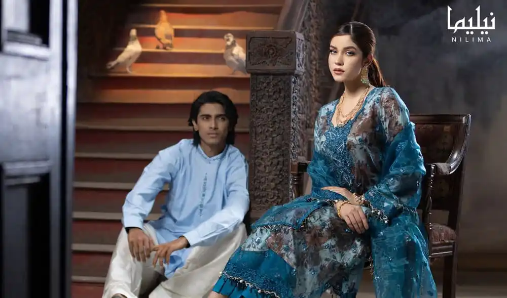 দুটি তরুণ নারী-পুরুষ ঐতিহ্যবাহী পোশাকে বসে থাকছেন।. Channel i News - চ্যানেল আই নিউজ