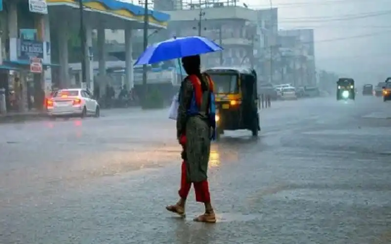 বৃষ্টির মধ্যে রাস্তায় হাঁটছেন একজন ব্যক্তি, ছাতা হাতে. Channel i News - চ্যানেল আই নিউজ
